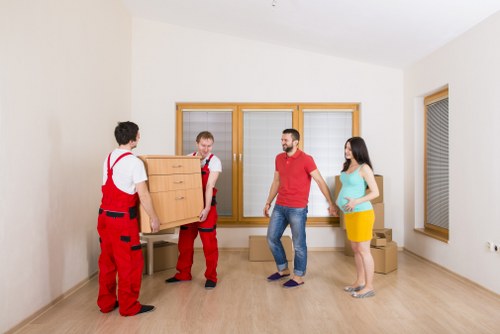 Careful furniture loading from a narrow stairway in a North London property